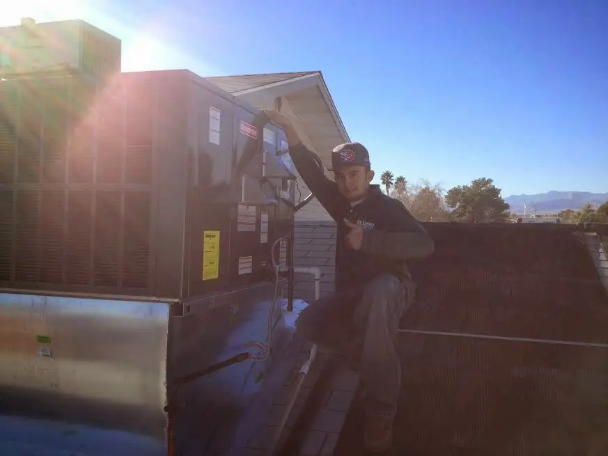 HVAC technician performing HVAC Inspection on a rooftop unit in Cambria